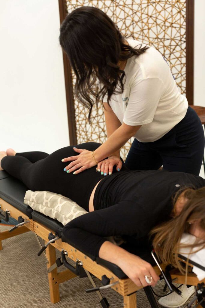 Dr Jessica assessing a pregnant woman's pelvis- Lighthouse Chiropractic and Wellness