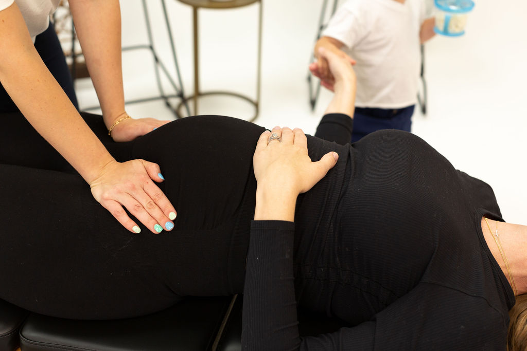 Dr. Jess with hands on a pregnant patient's belly